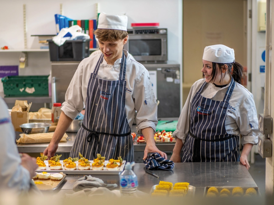 Two student making desserts