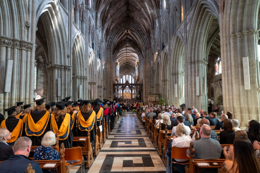 Graduands and guests sit together in a cathedral