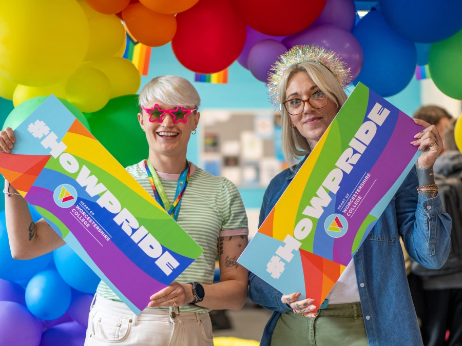staff members holding up HoW Pride boards