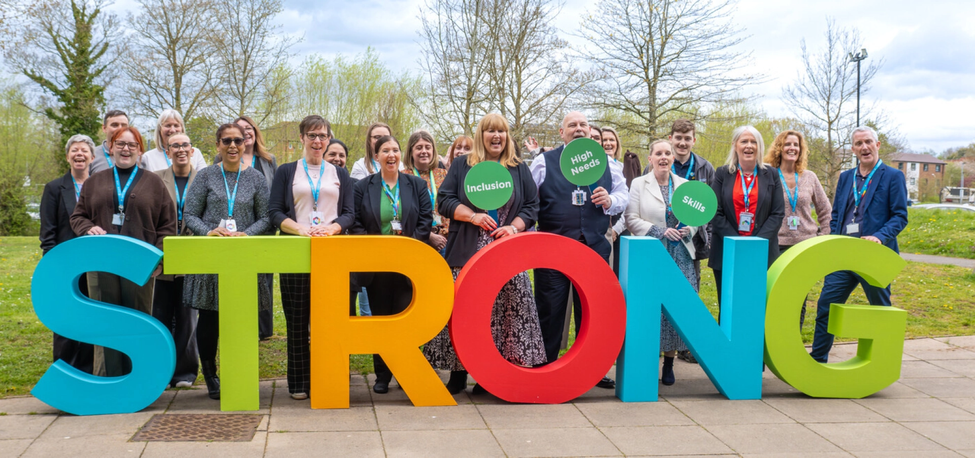 staff stood in front of STRONG letters cheering