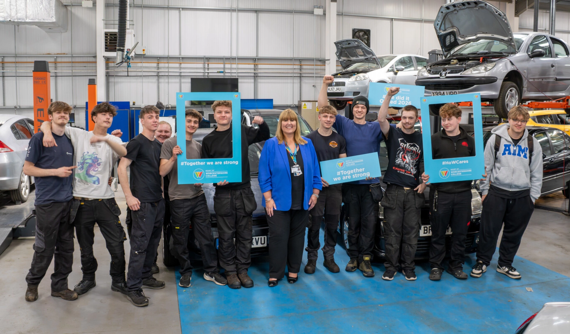 students in automotive workshop with principal