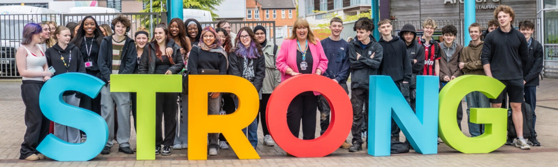 Students around Strong Letters underneath the canopy at the Redditch College Campus