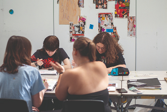 Students sat at a table together in an art classroom