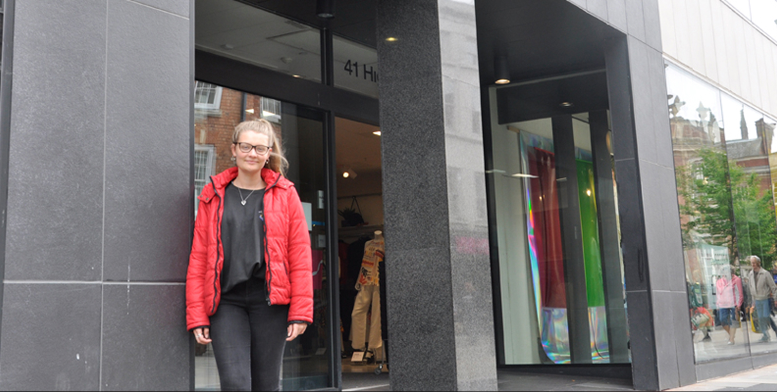 Student standing outside of shop