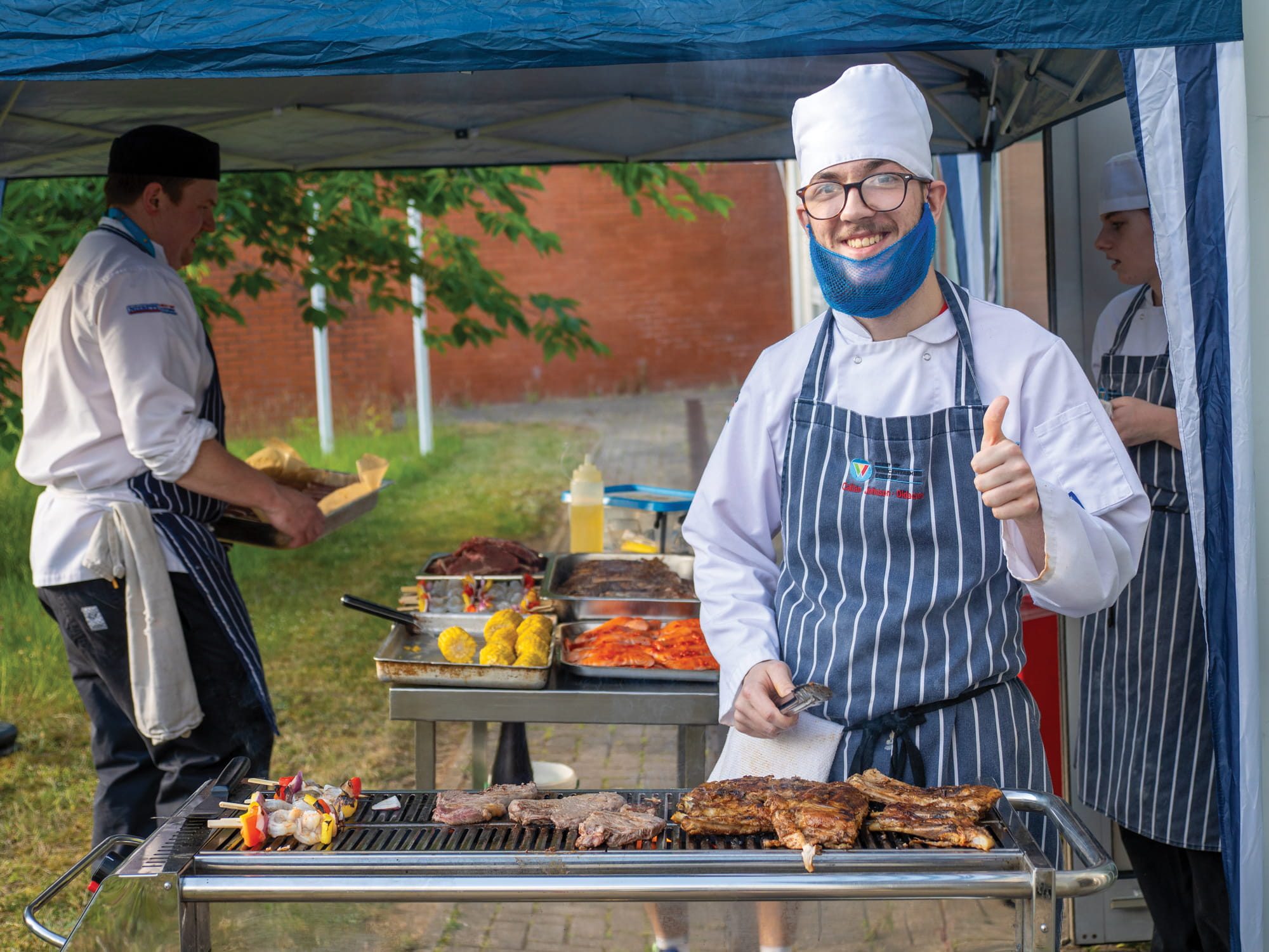 Student barbecuing food outside