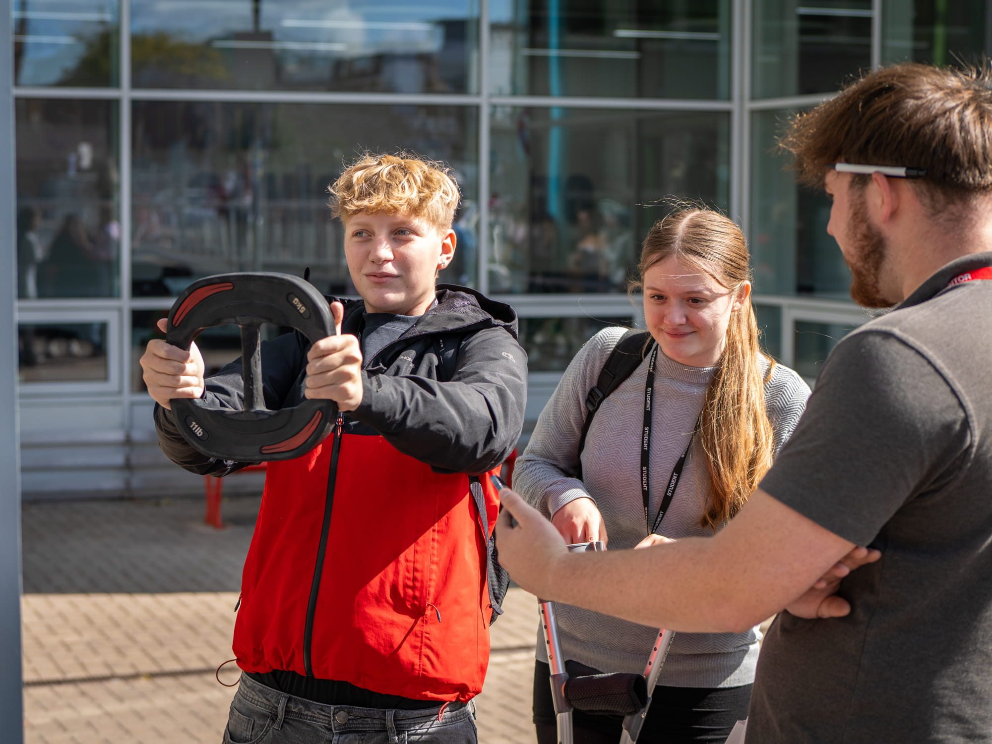 Student holding a wheel with two others watching