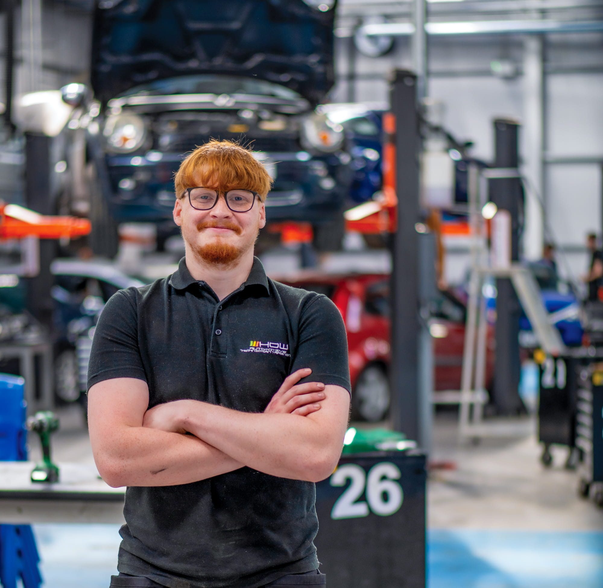 Student with arms crossed in car garage