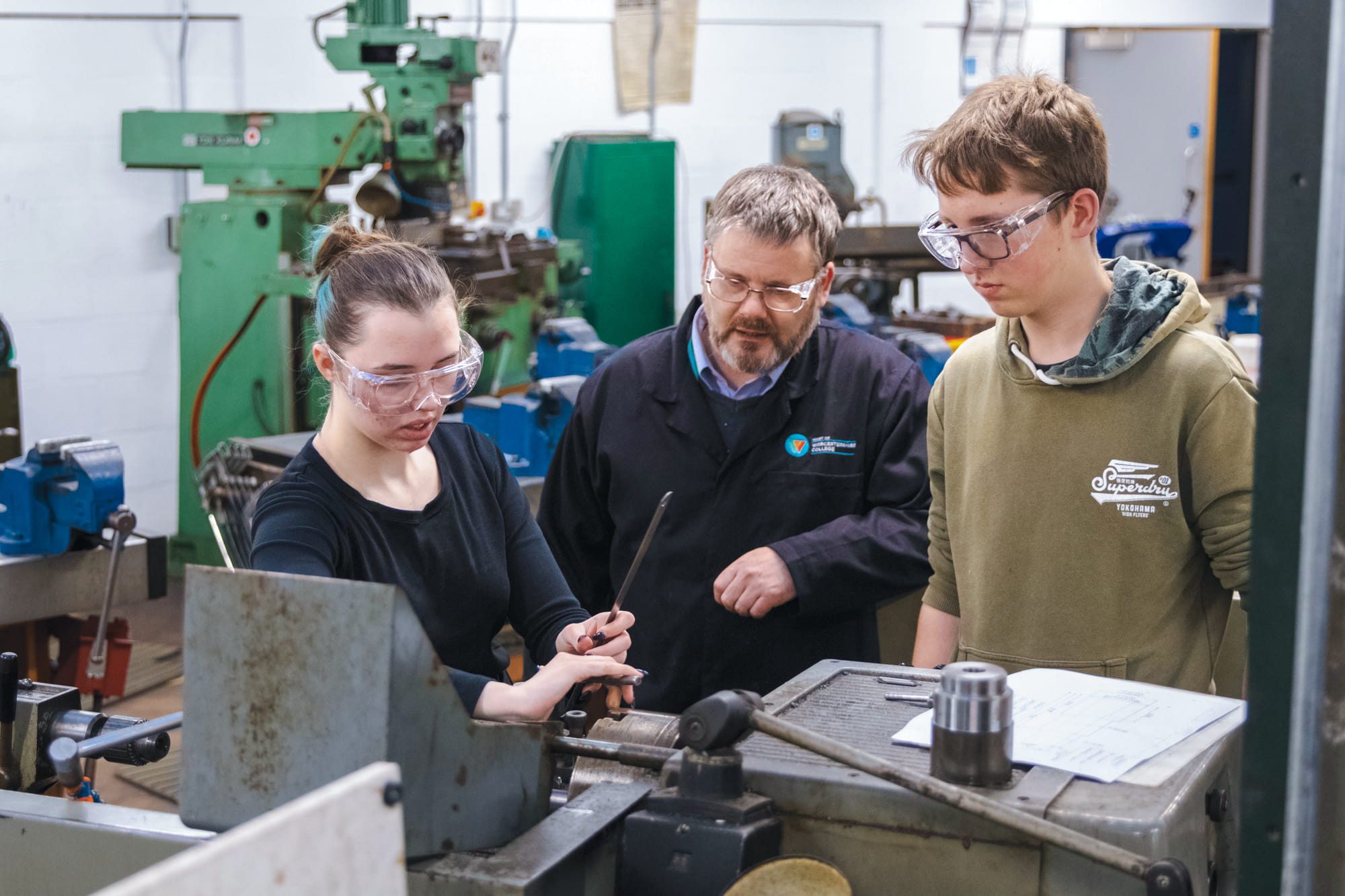 Teacher helping students with engineering equipment