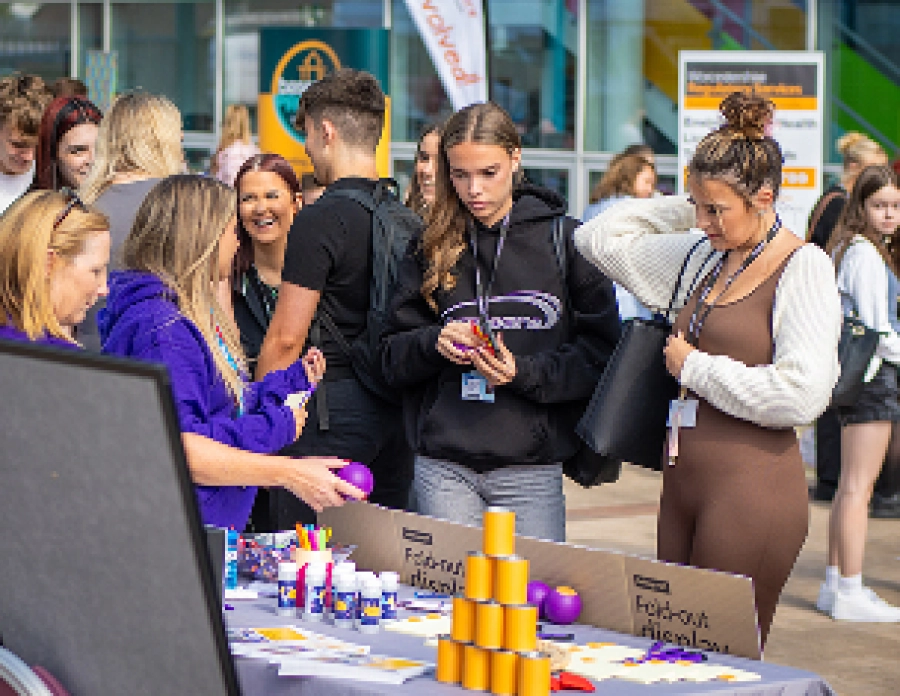 Students at freshers fair talking to a stall