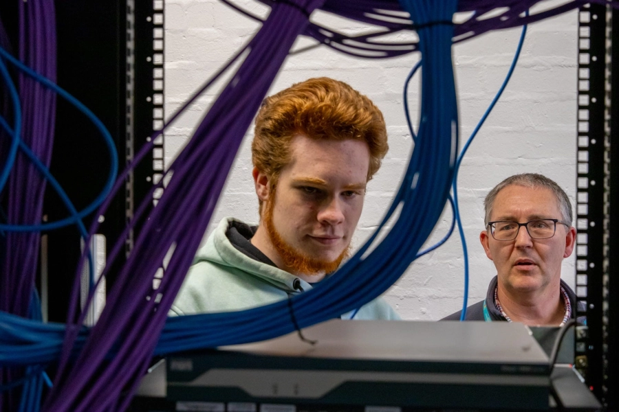 Student and tutor looking at computer wiring