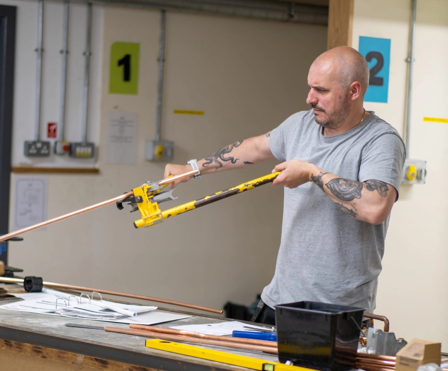 Student bending pipes in a construction workshop