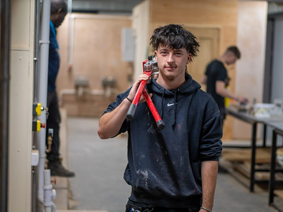Student holding tool in a workshop