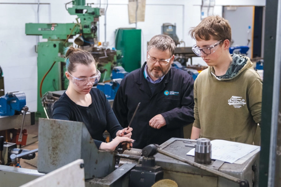 Teacher helping students with engineering equipment