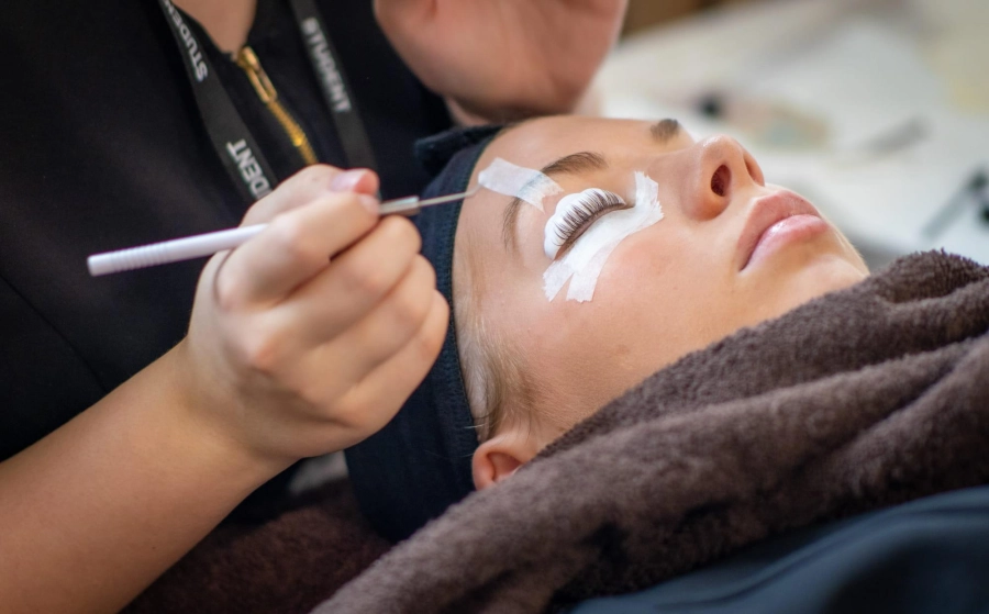 Student having false eyelashes put on