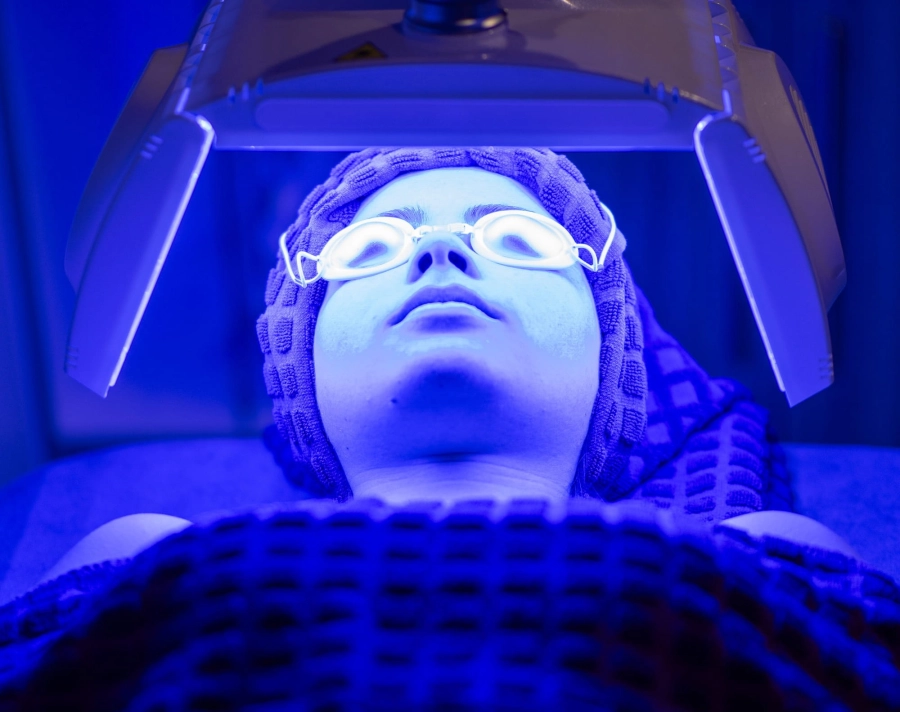 Student lying down underneath an LED blue light