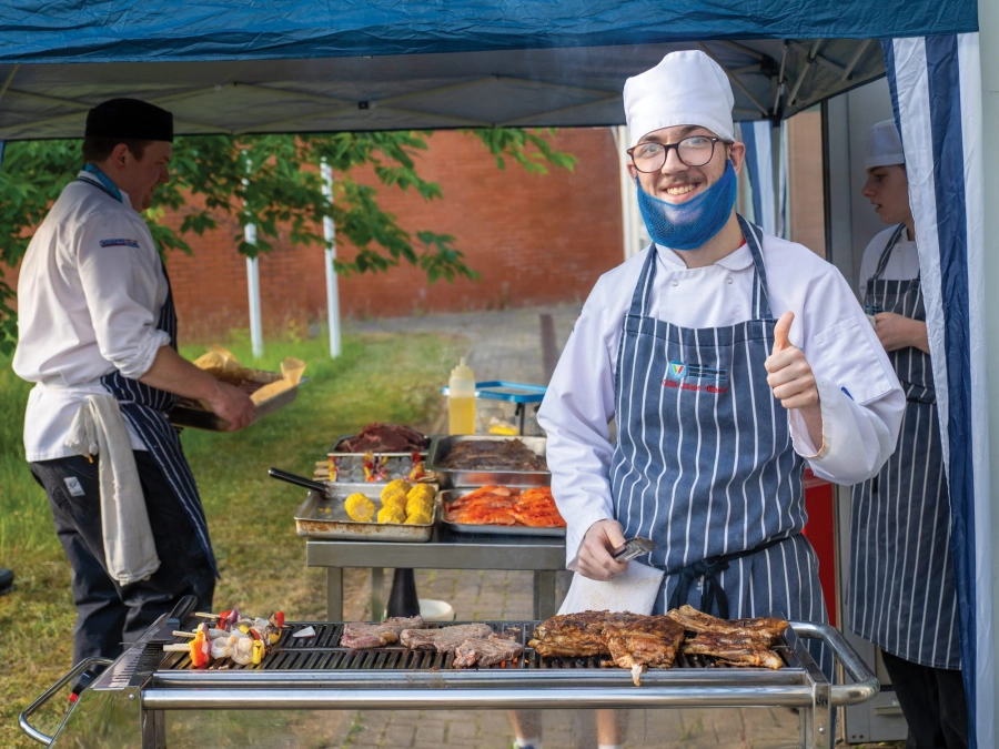 Student barbecuing food outside