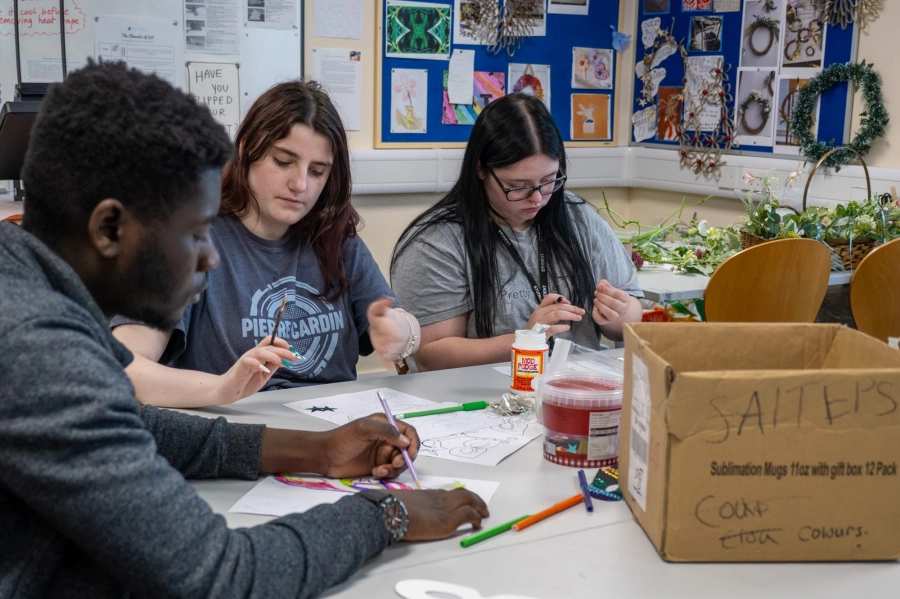 Three students doing arts and crafts
