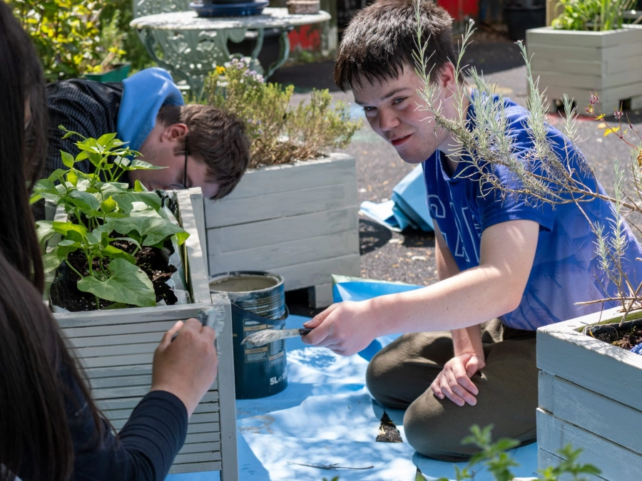 Students sat outside painting plant pots