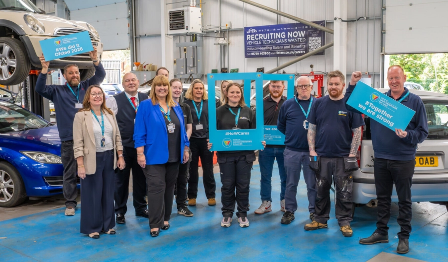 Picture of ELT members and tutors celebrating the Ofsted results with frames and boards in an automotive garage