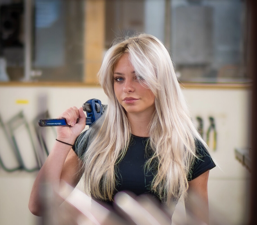 Engineering student stood holding a tool in workshop