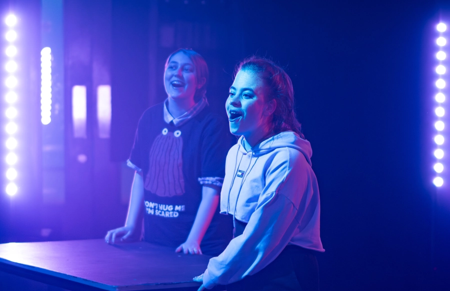 Two performing arts students stood on the stage happily singing