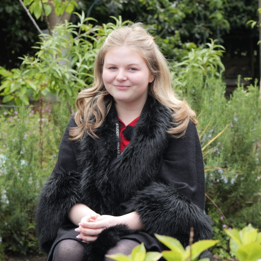 A picture of Darcy a student at HoW College who is smiling for a photo outside.