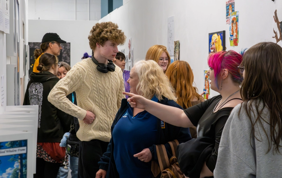 Students showing people around the art exhibition that they put on
