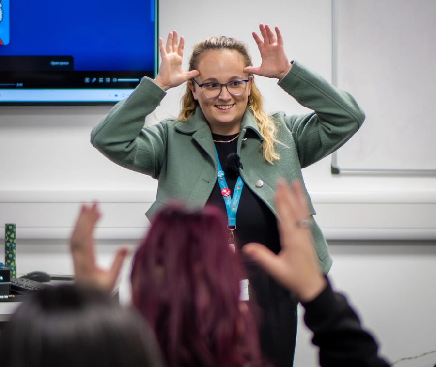 Tutor with her hands on her head speaking with students in a classroom