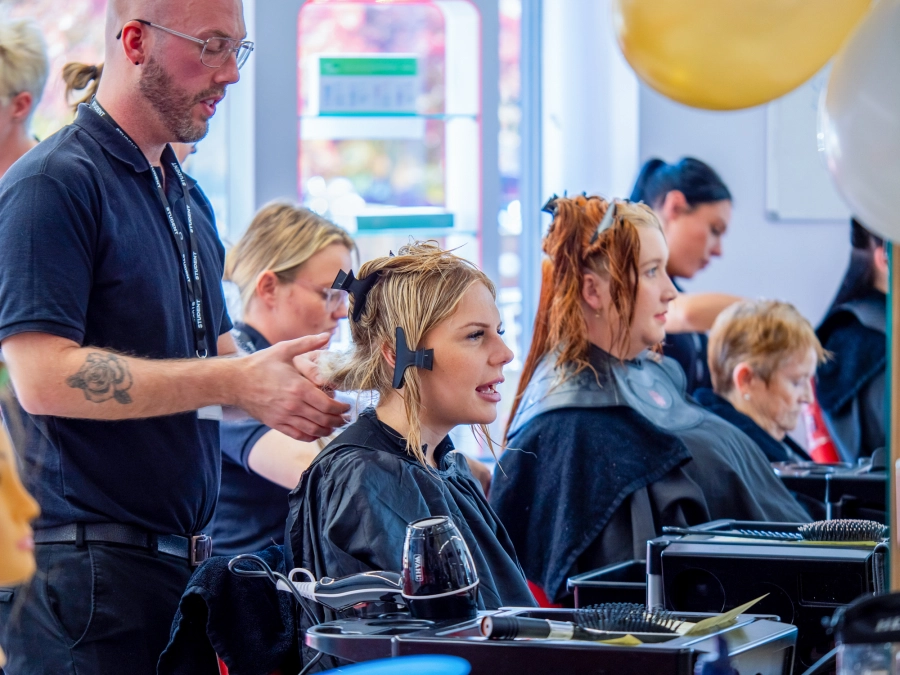 Student doing another students hair in hairdressing salon
