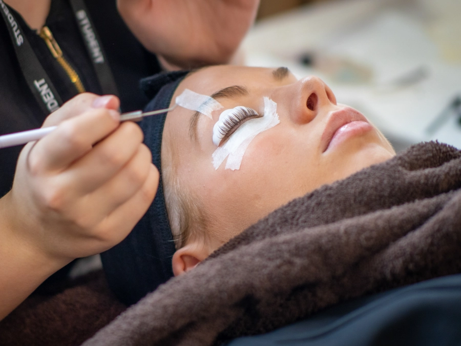 Student having eyelash extensions applied.