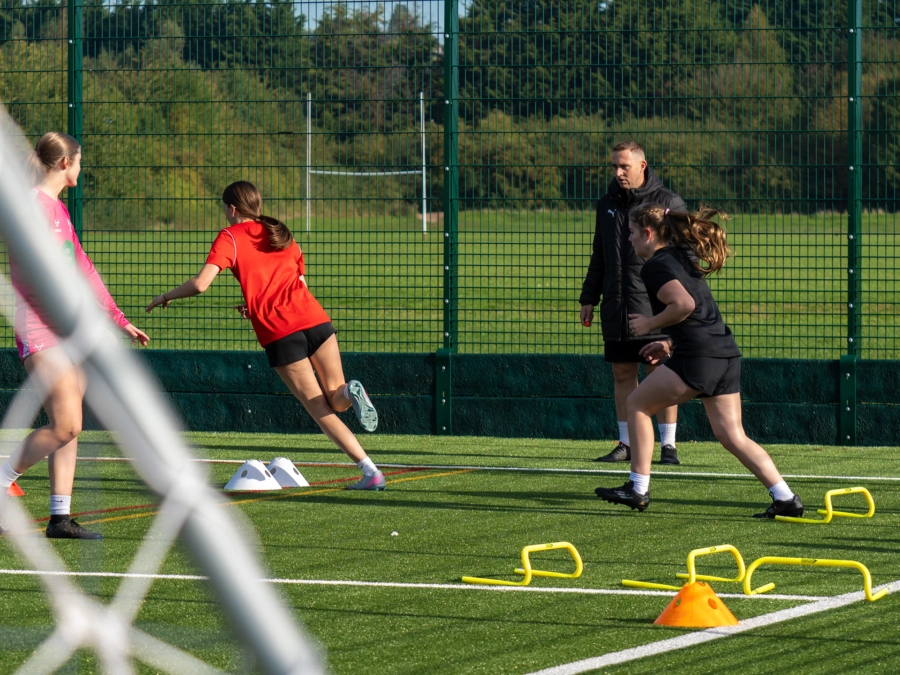 Females on a field doing football training exercises