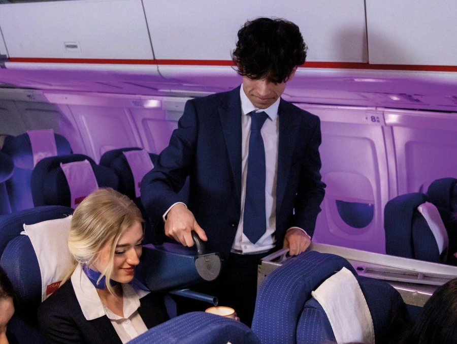 Student serving a drink to another student in the mock air cabin