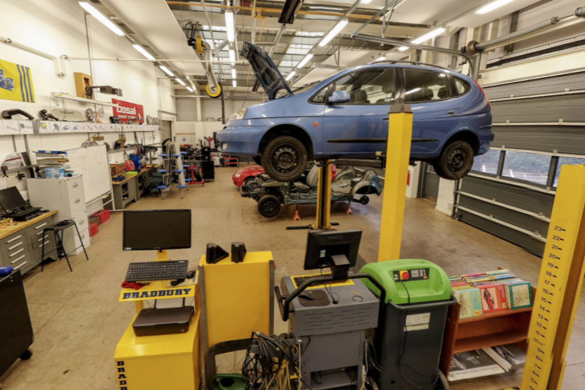Automotive workshop garage with car suspended in the air