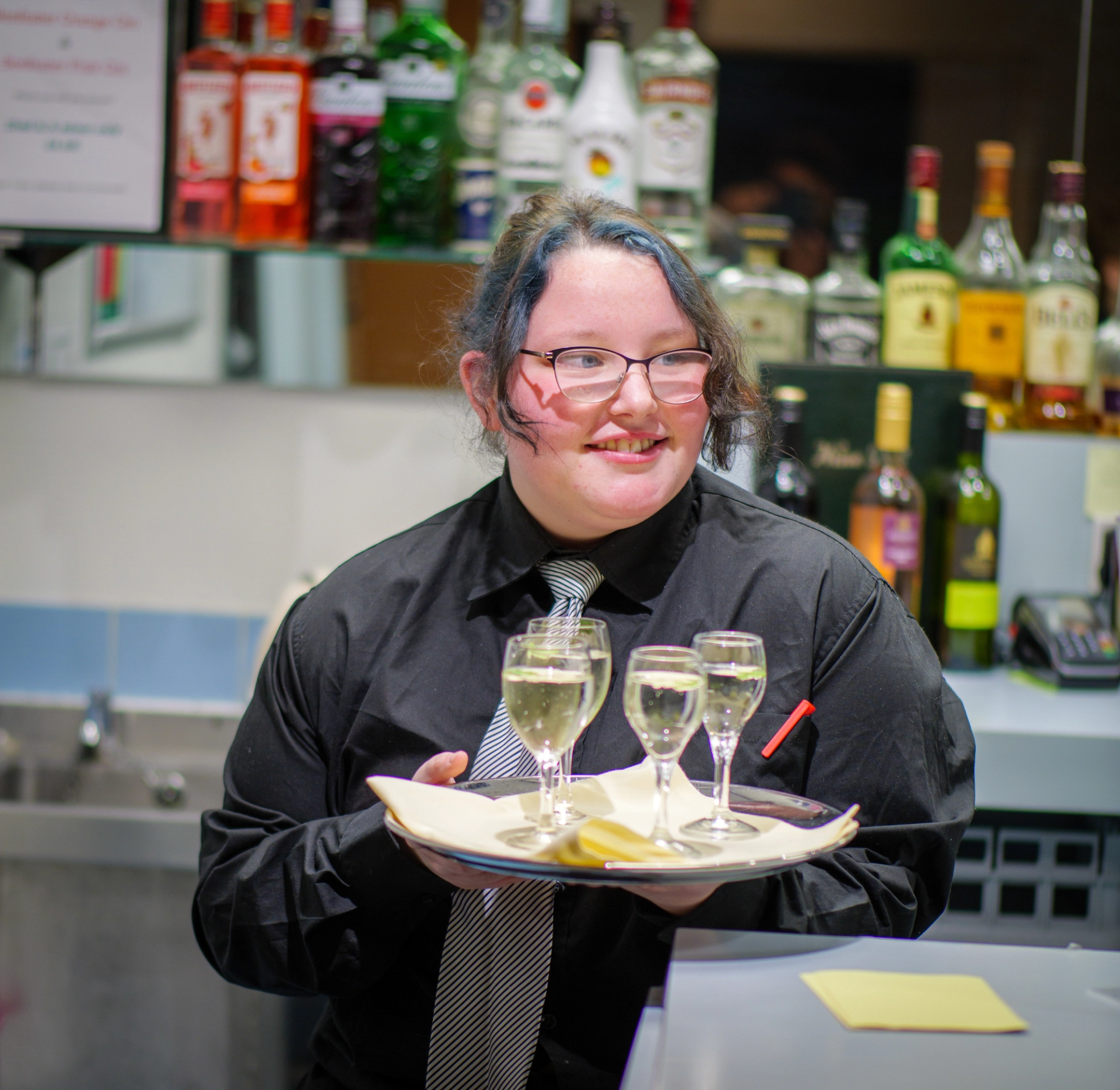 Student holding drinks on tray in archers restaurant
