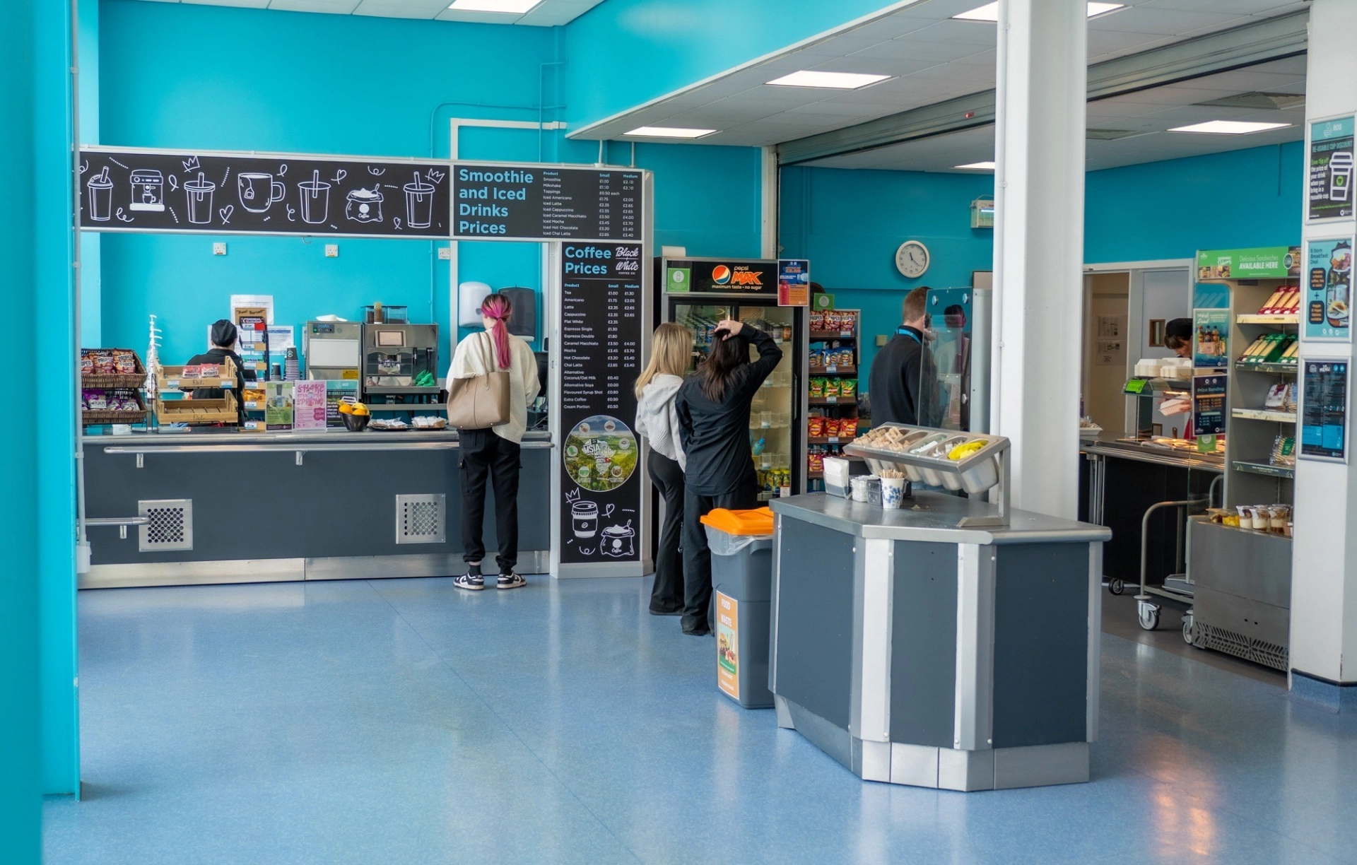 Several people standing in a cafe