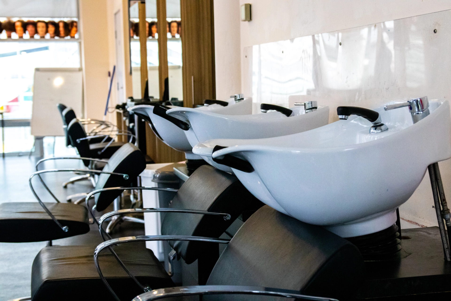 Hair washing station in commercial salons including basins and chairs