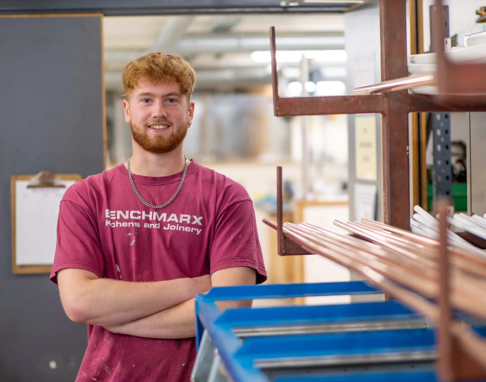 Student stood in a workshop posing for a picture with arms crossed