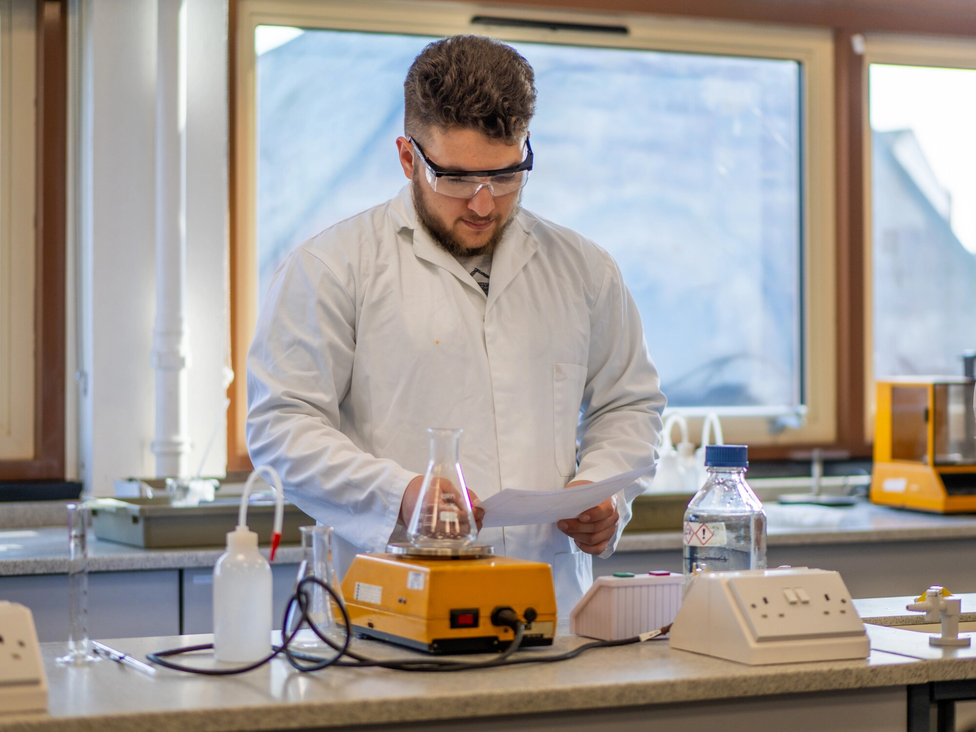 student working in science lab in goggles