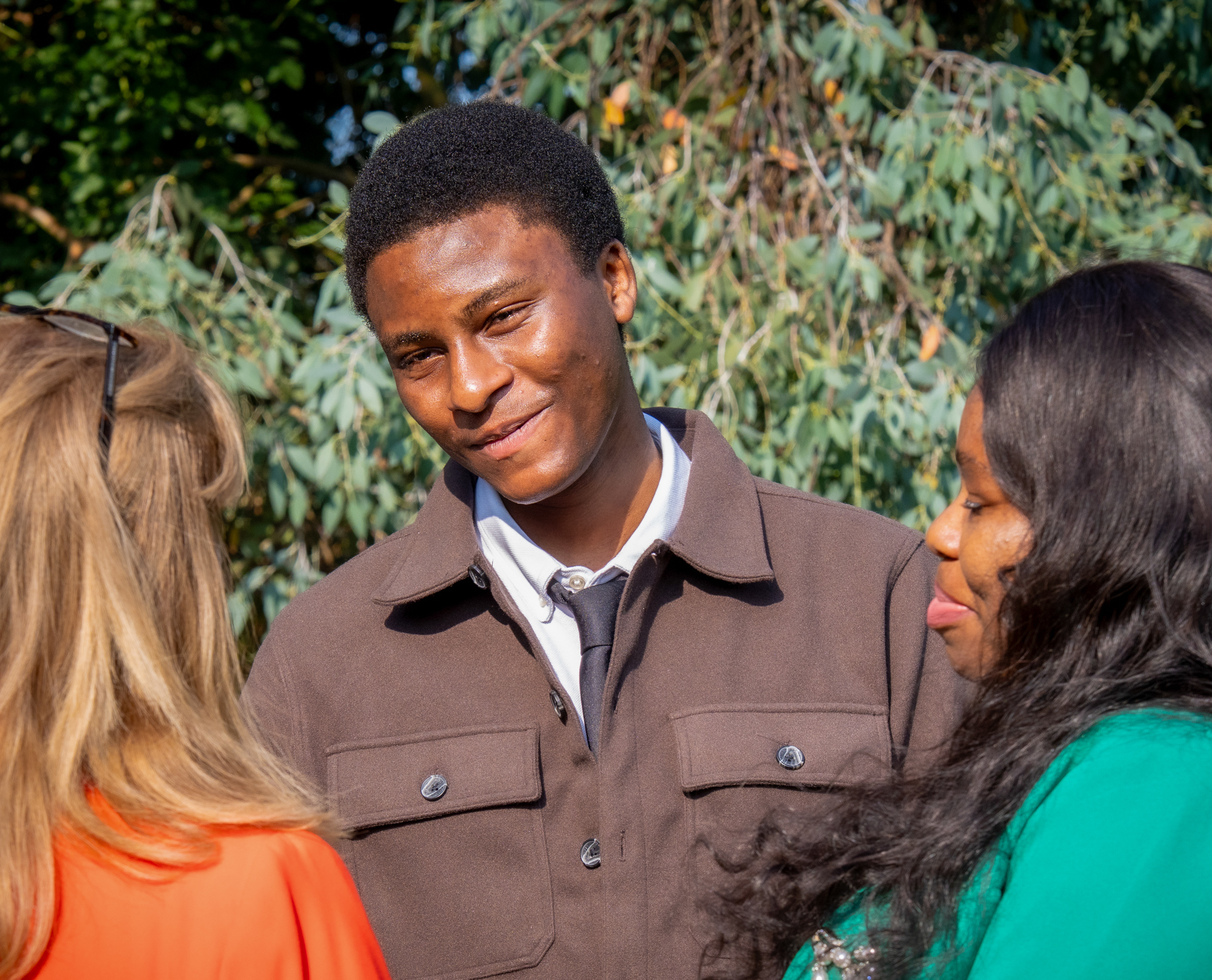 Picture of a student and their family smiling talking with principal of HoW College