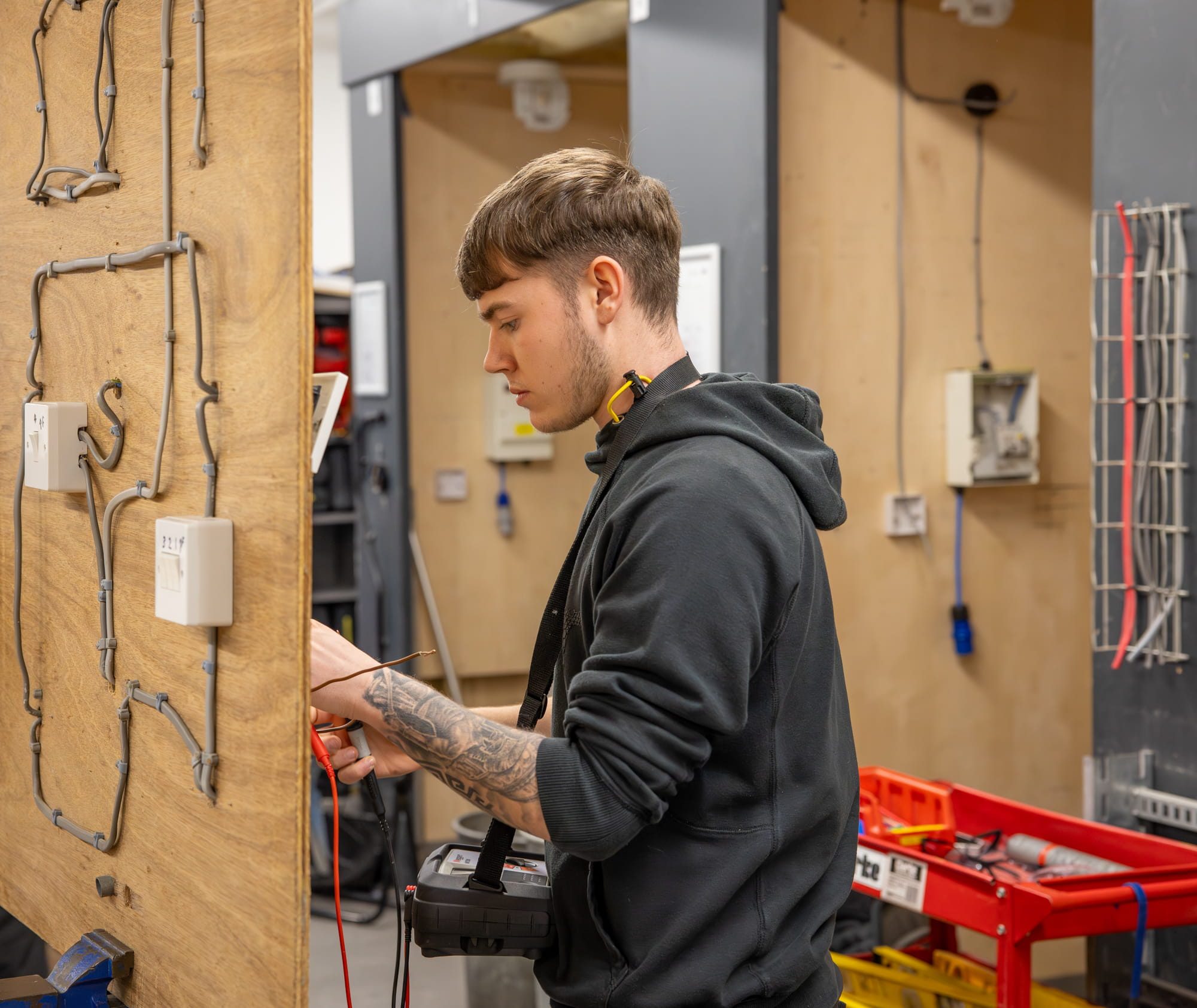 Student working in electrical workshop wiring a socket on a practice board
